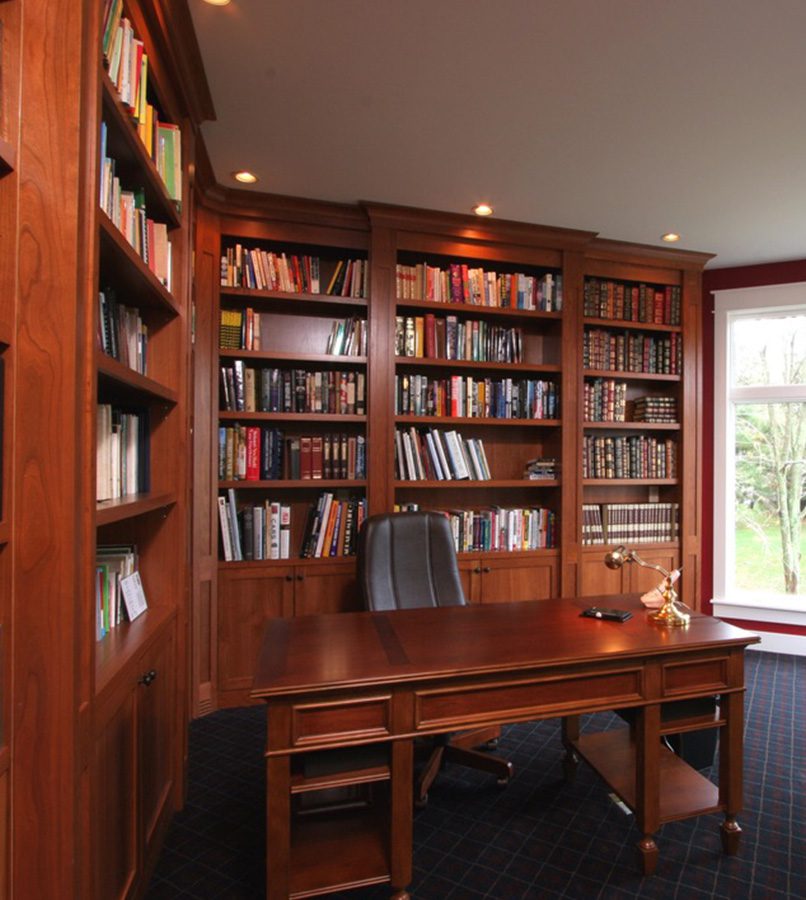 Home office with wooden bookshelves and desk.