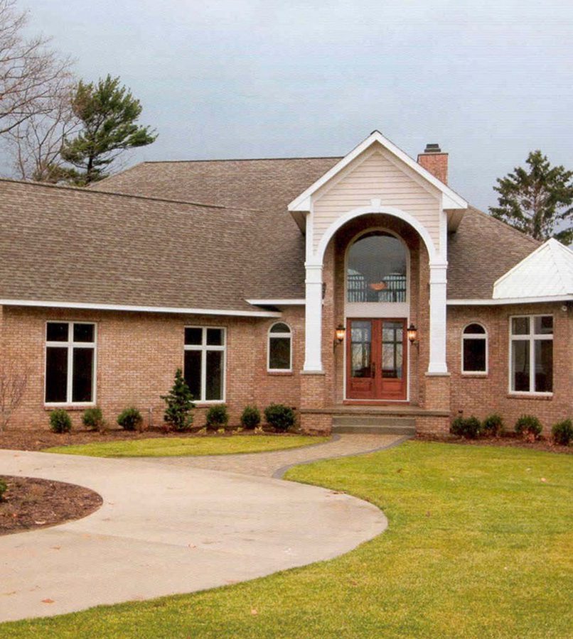 Modern brick house with arched entrance.