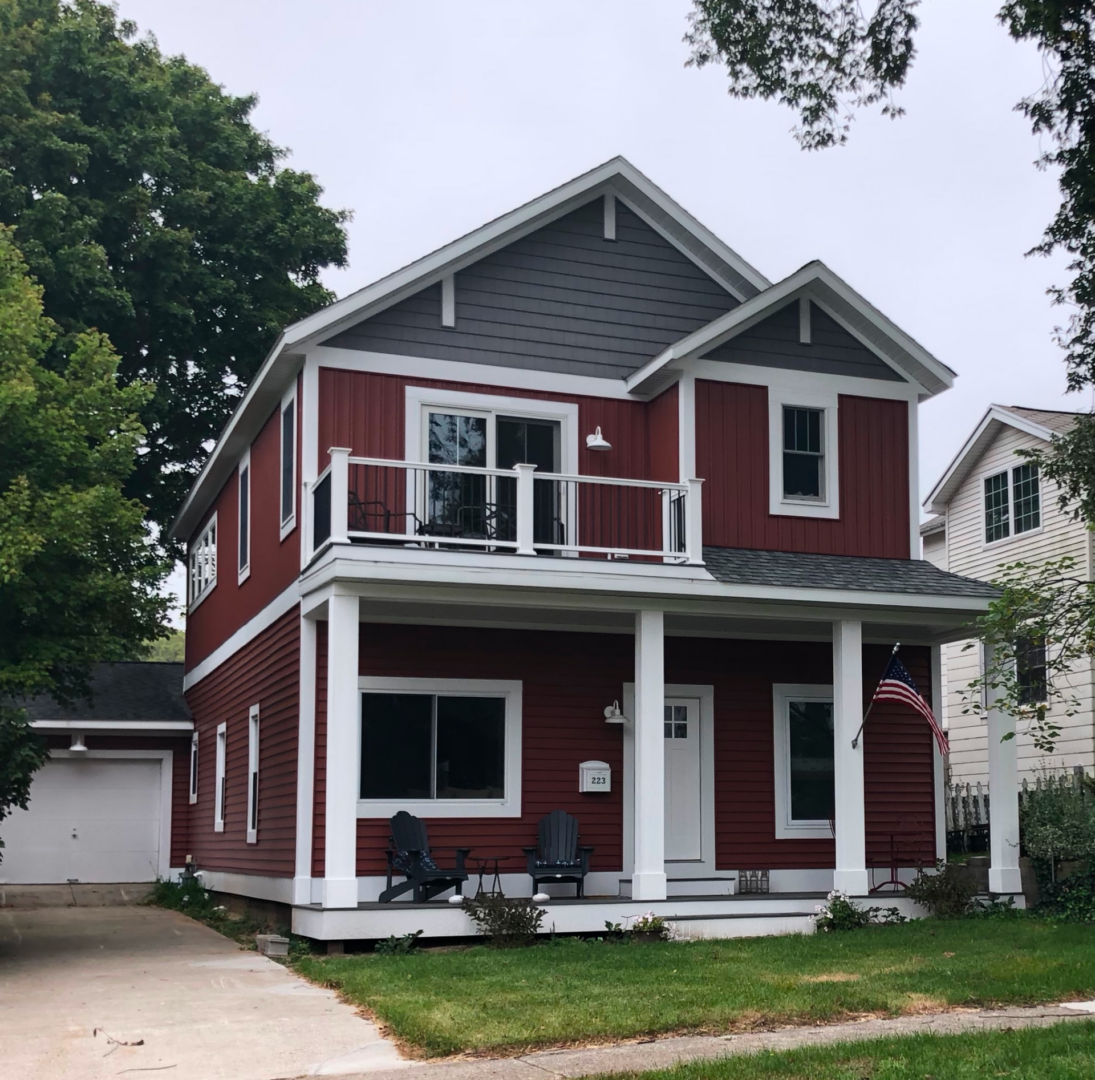 Red house with porch and American flag.