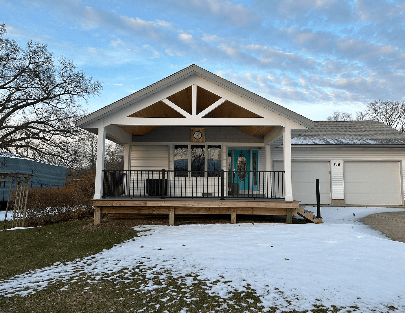 House with porch and snowy yard.