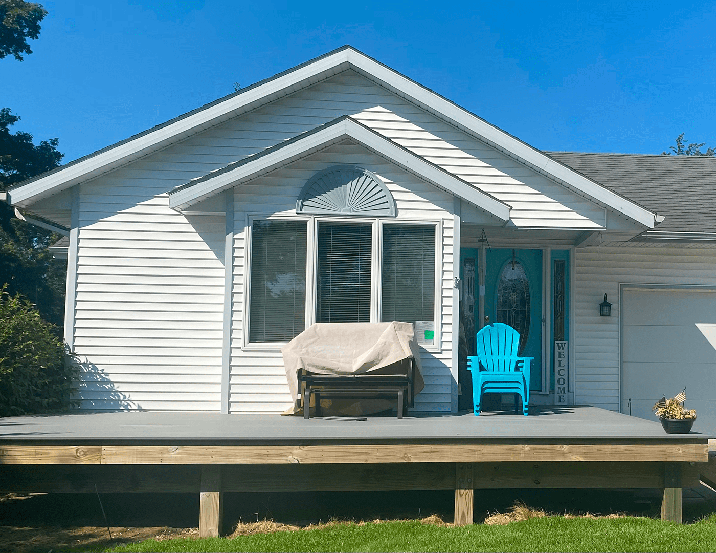 White house with blue chair on porch.
