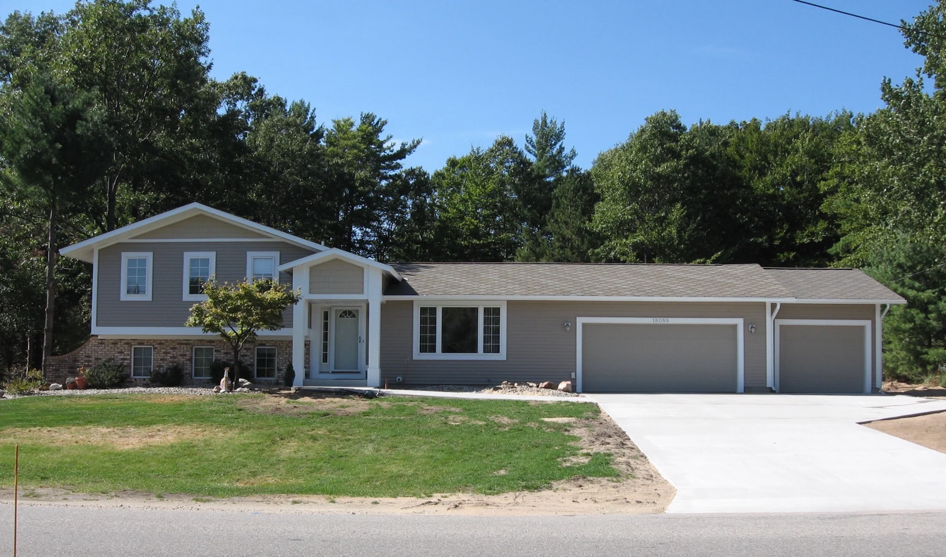 Suburban house with large driveway and garage.