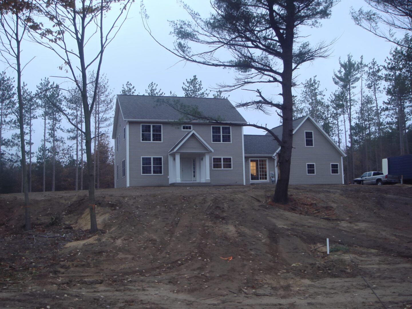Two-story house surrounded by trees.