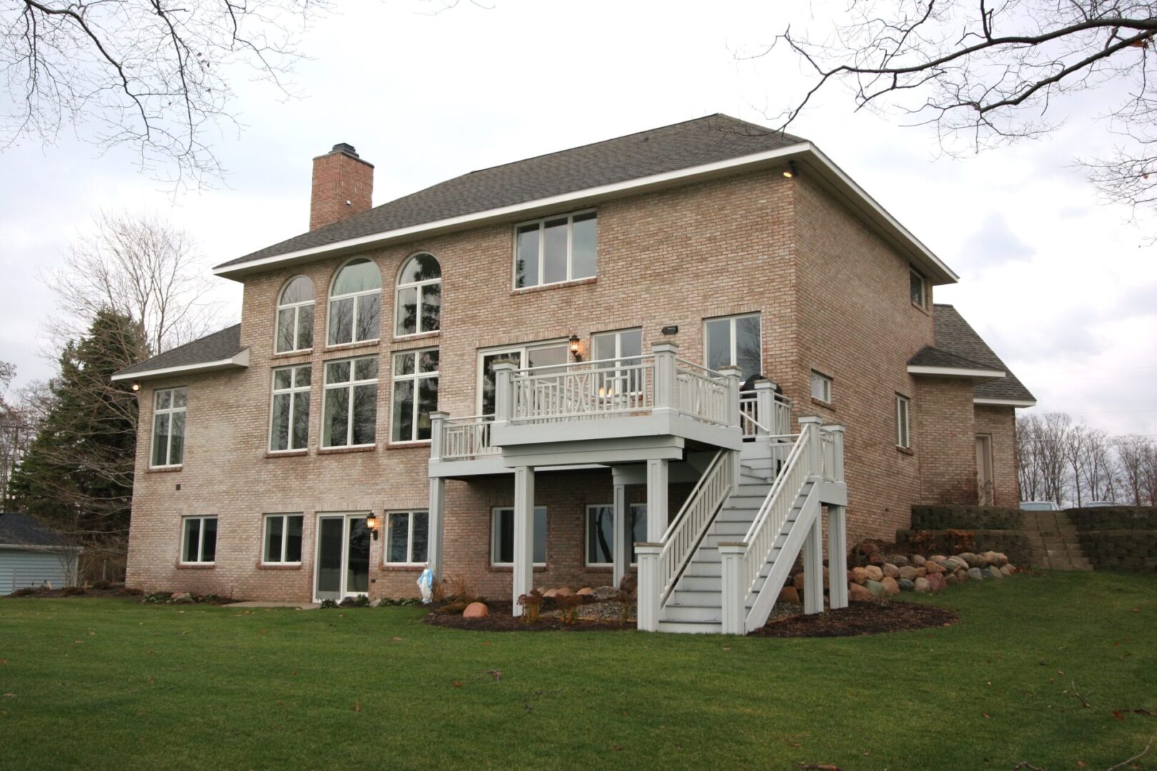 Large brick house with a backyard deck.