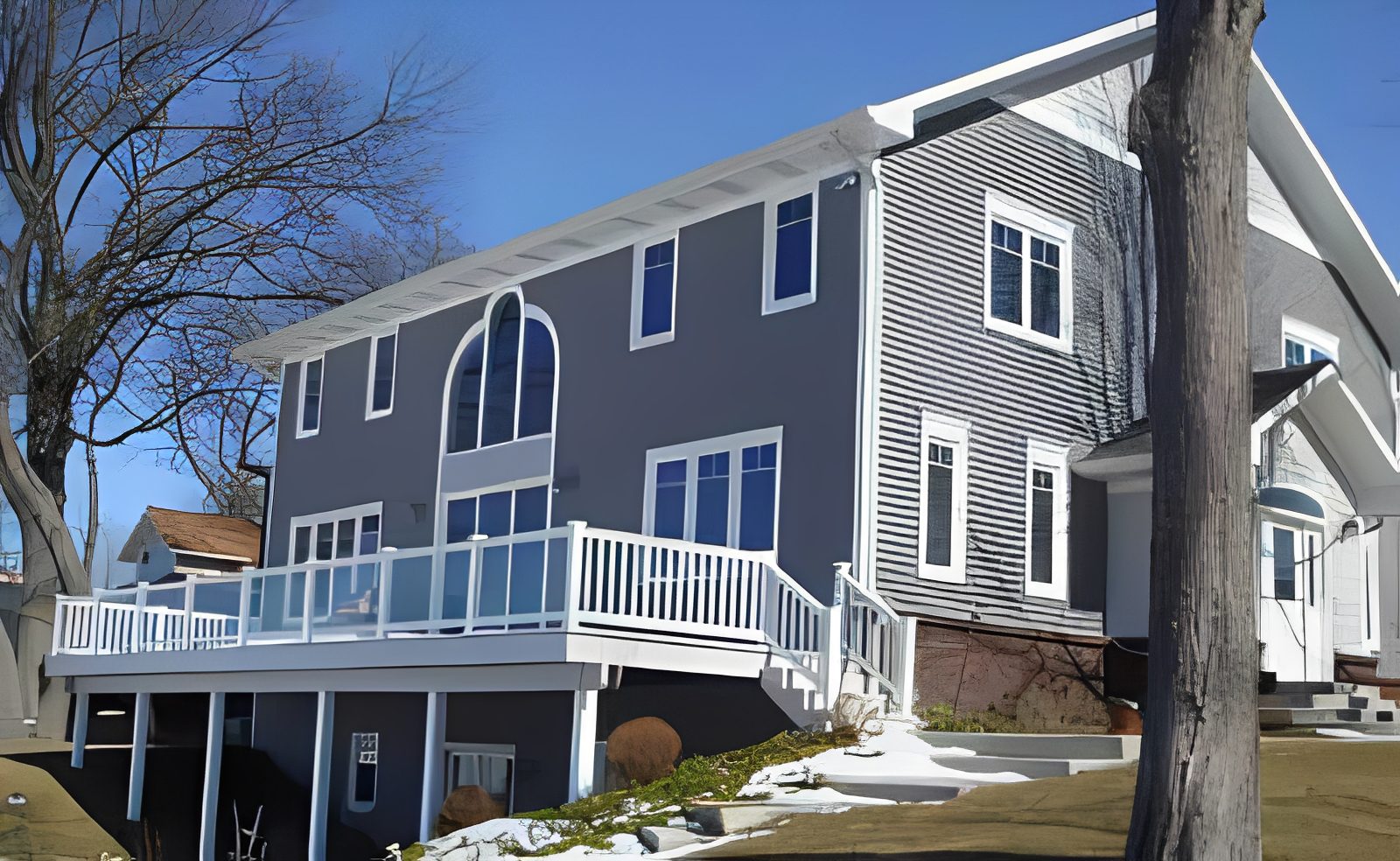 Modern grey house with large deck.