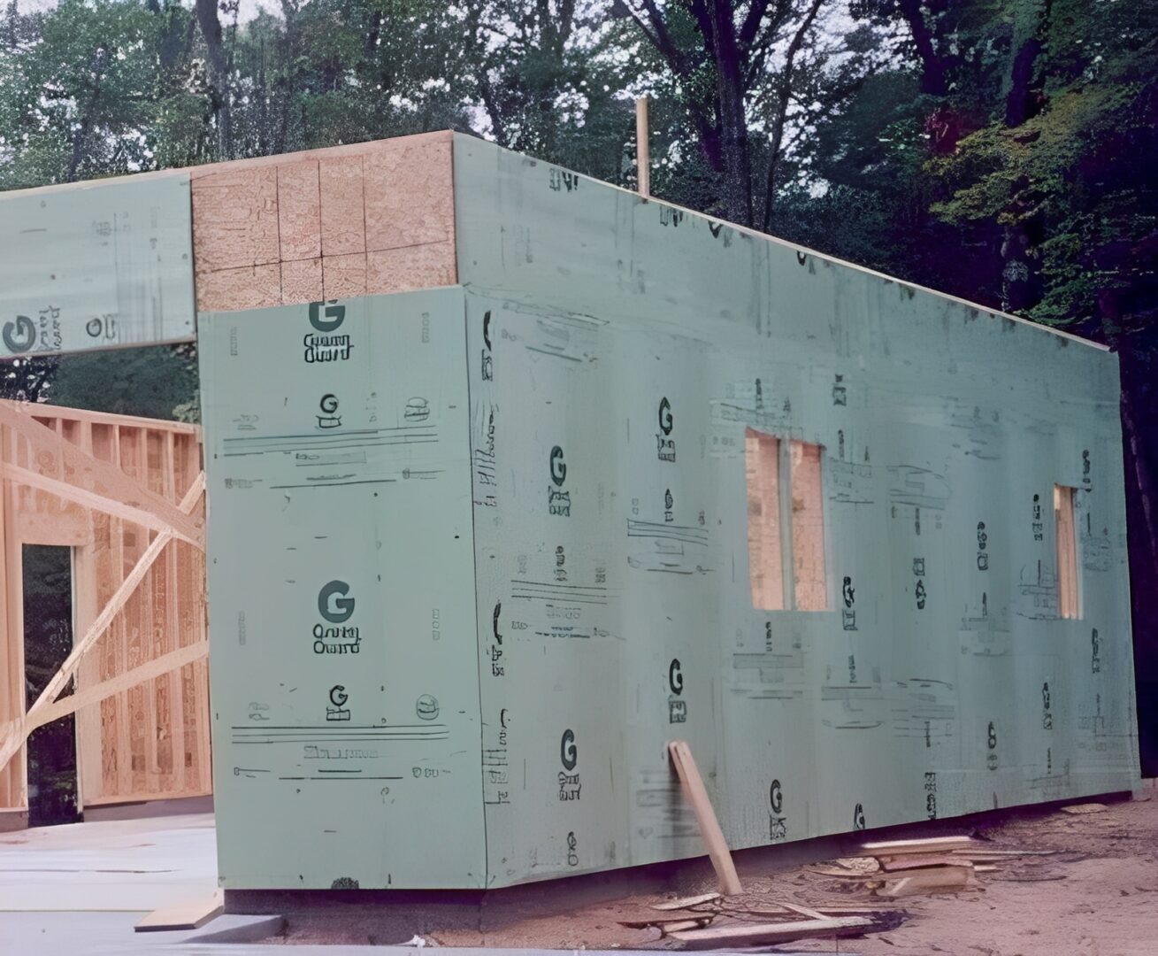House frame with green sheathing under construction.